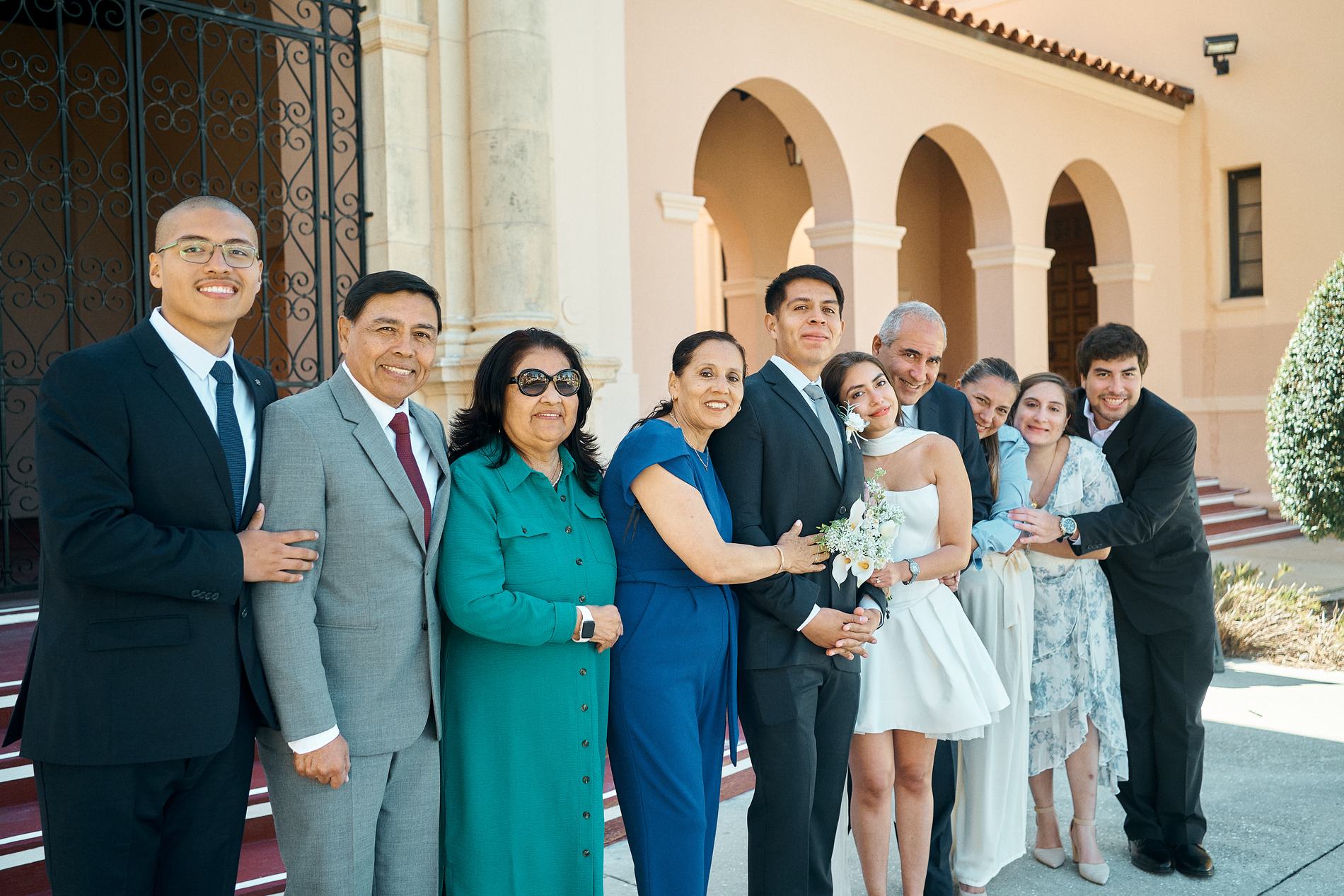 A family of twelve standing together with the bride and groom at the Sarasota Historic Courthouse