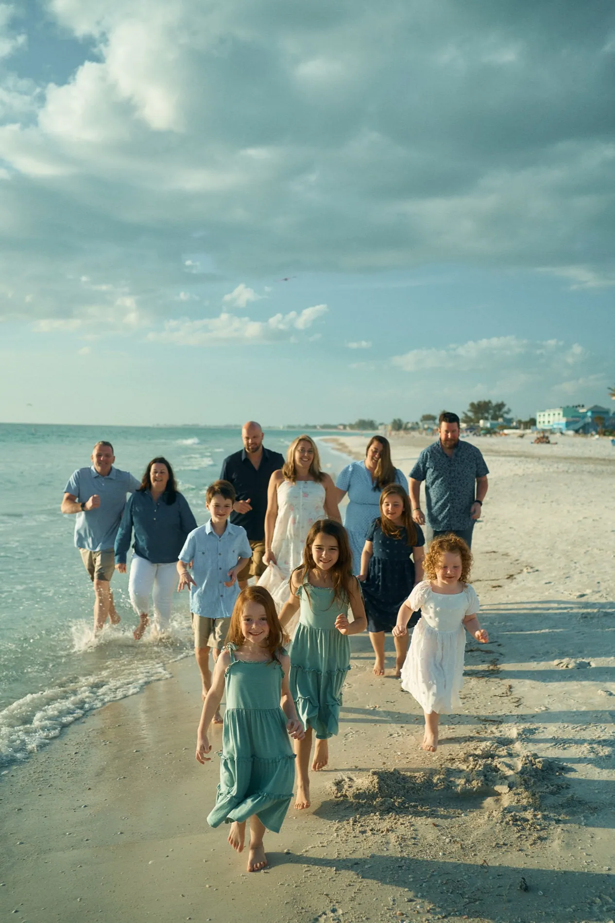 A large family of eleven running together along the shore on Anna Maria Island
