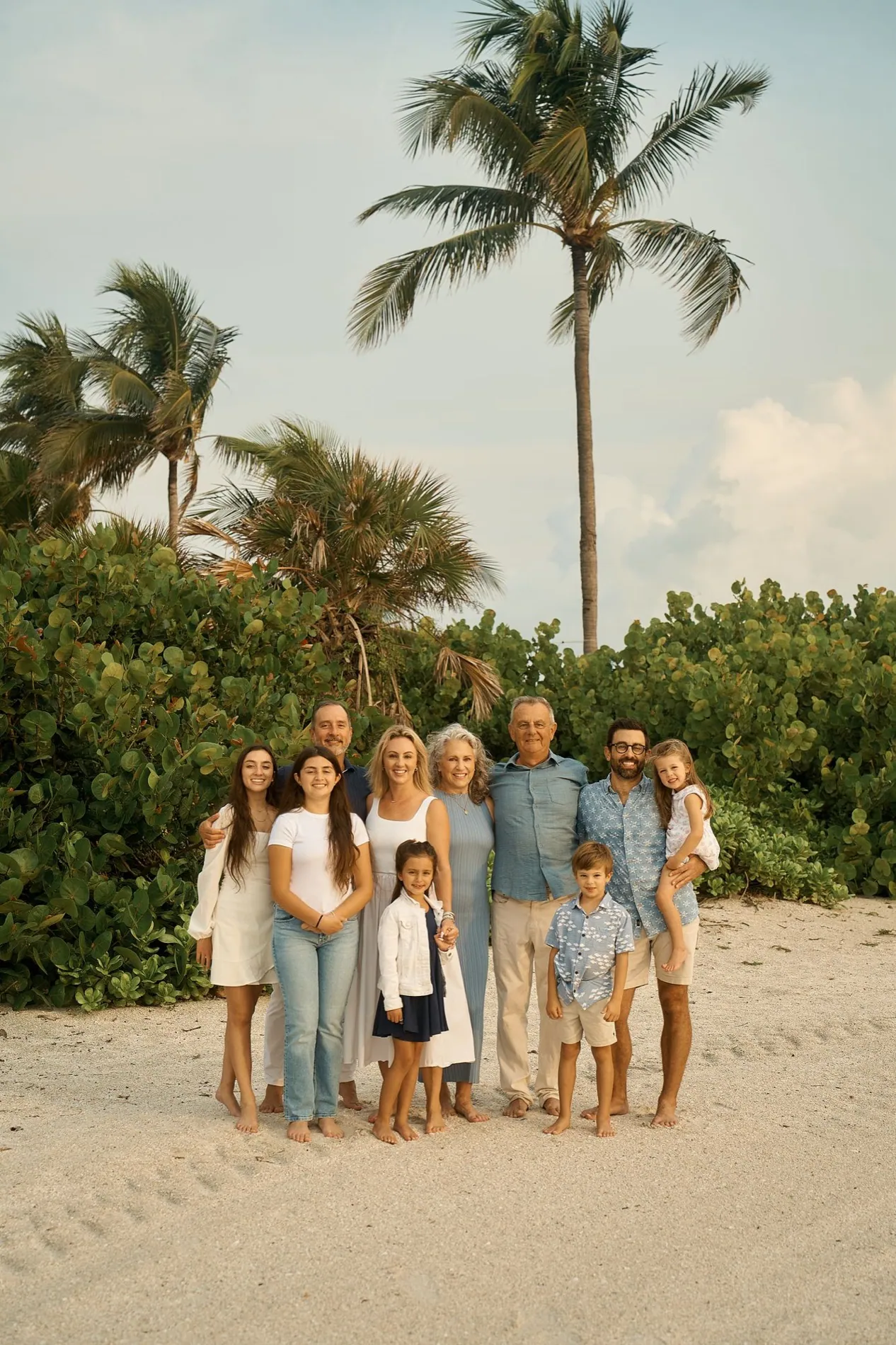 A large family standing together under a palm tree on Lido Key