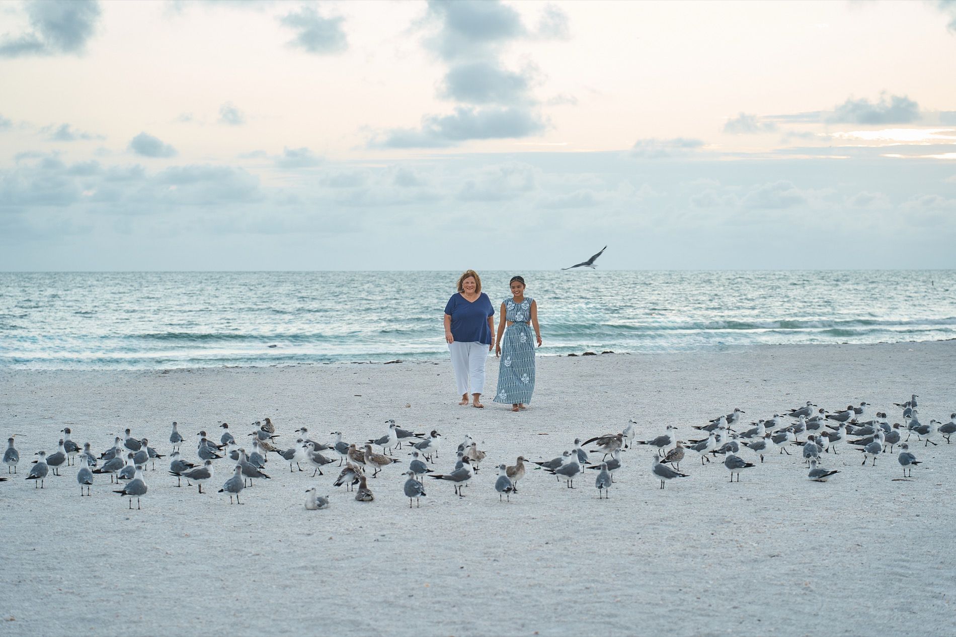 A couple standing on Lido Key beach among a flock of shorebirds