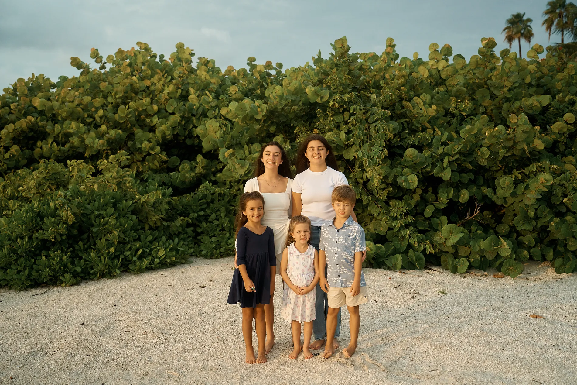 Five cousins without the grown-ups on a sandy path through the sea grape on Lido Key: two teenage girls at the back and three little ones in front