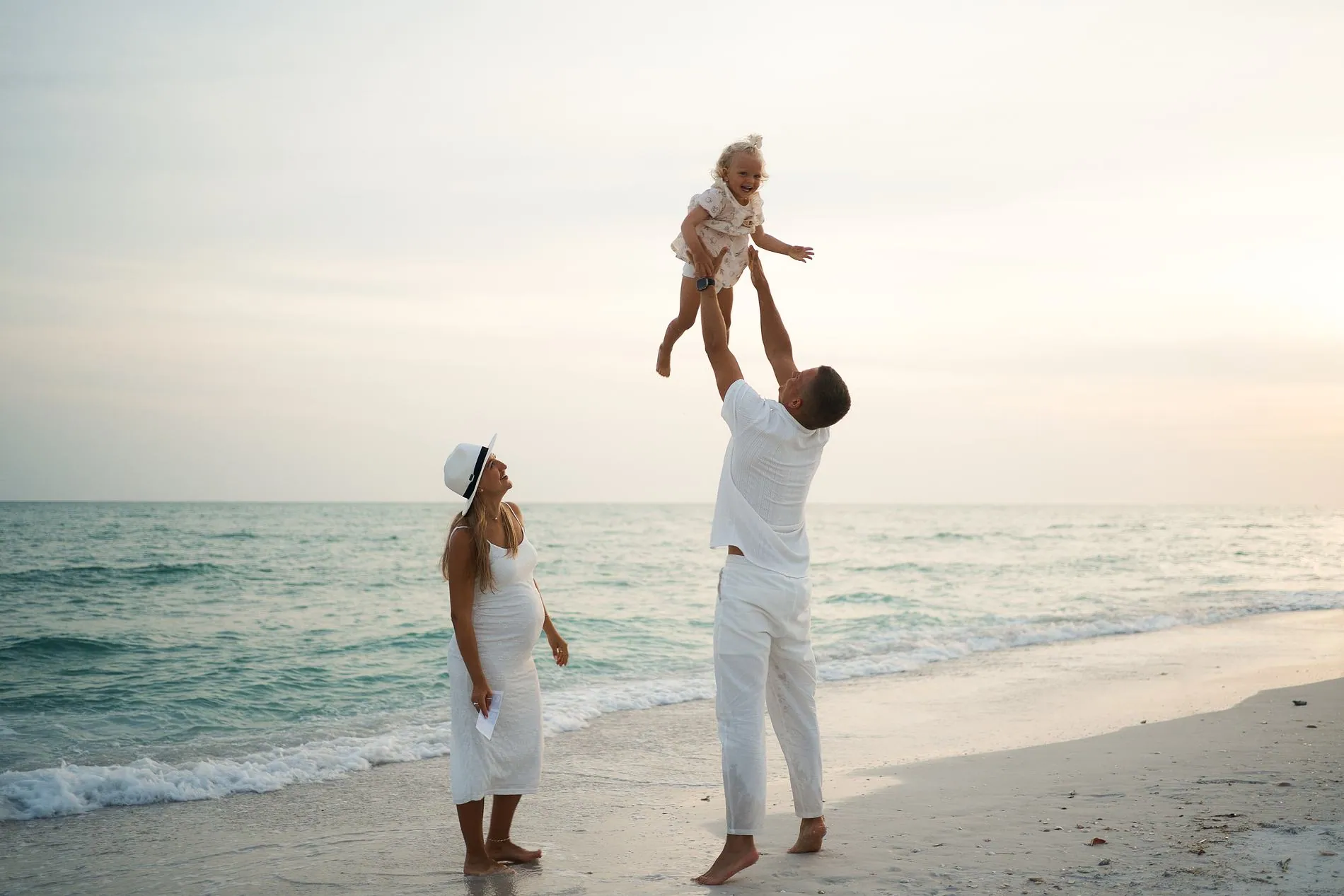 A father lifting his child at the water on Longboat Key