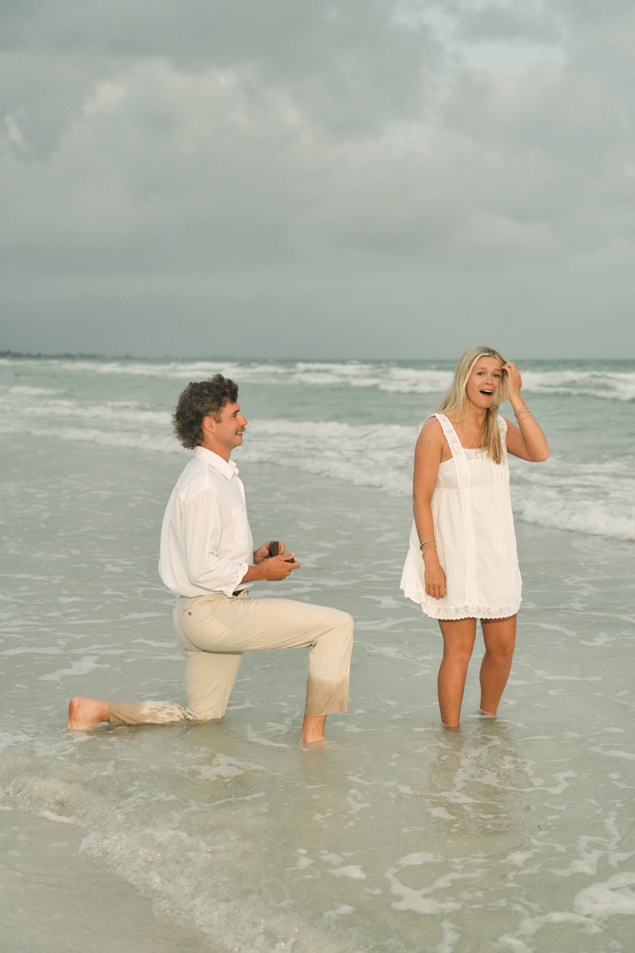 A man proposing in the shallow water on a Gulf Coast beach