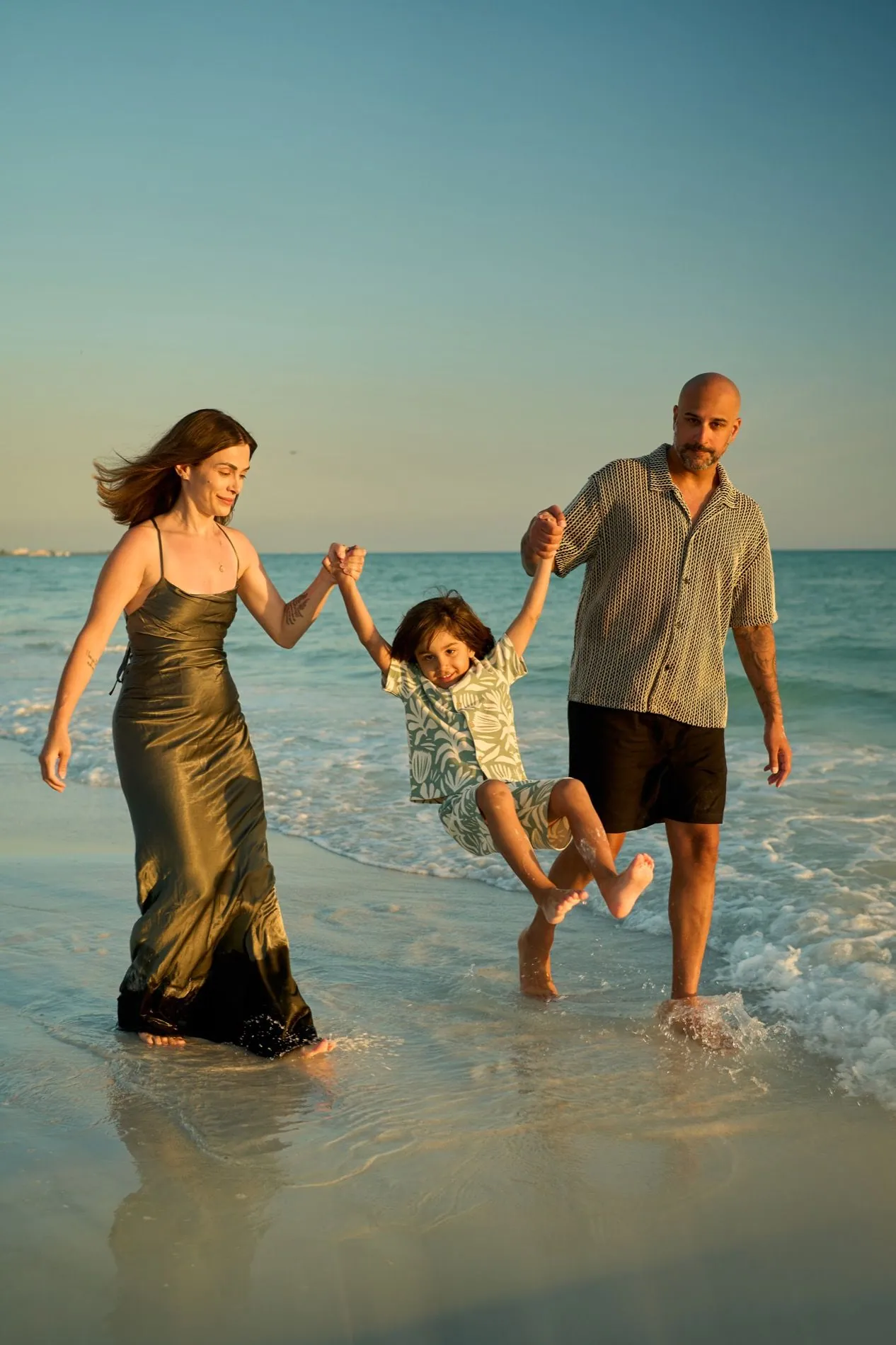 Parents swinging their son at the water on Siesta Key